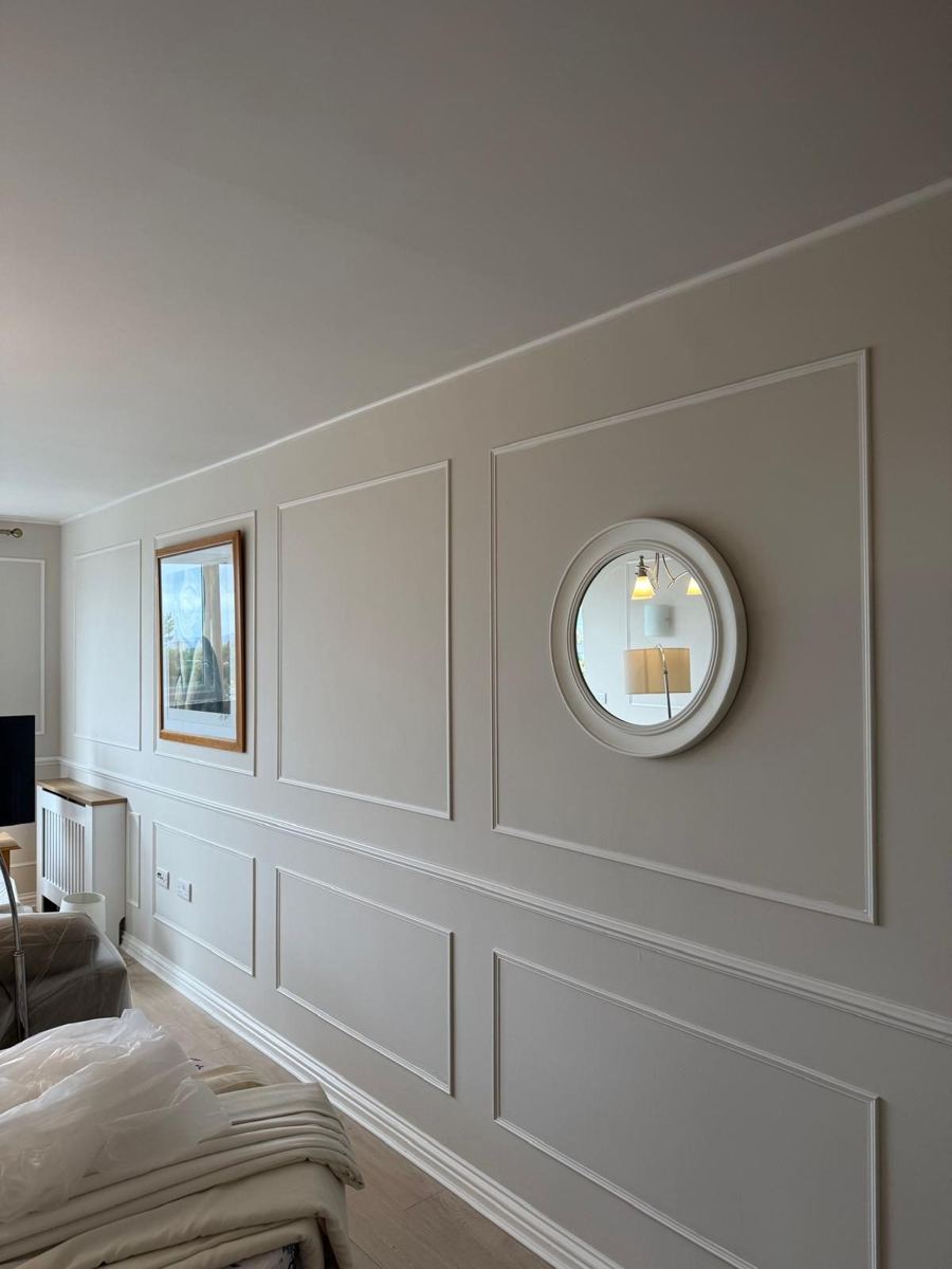 The same wall with panel moulding, dado rail, fresh paint and a round mirror hung